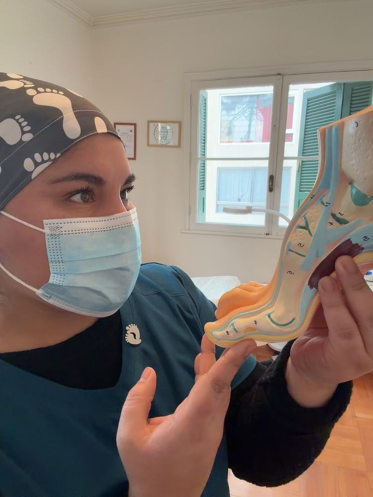 Carolina Cepeda explicando la anatomía del pie con un modelo anatómico en su consulta
